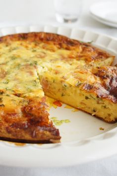 a quiche on a plate with one slice missing