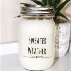 a glass jar filled with white liquid sitting next to a potted aloen