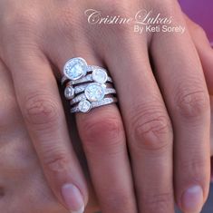 a woman's hand with three diamond rings on her left and the other hand holding an engagement ring