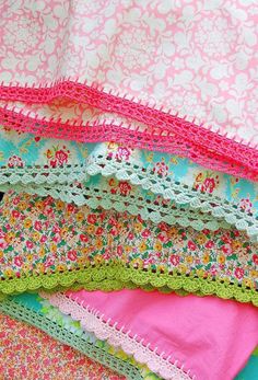 many different types of crocheted doily on a bed sheet with pink and green colors