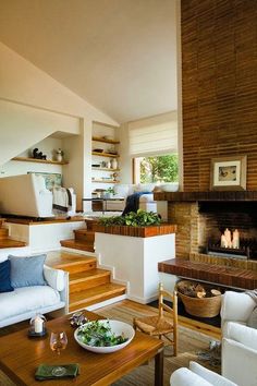 a living room filled with furniture and a fire place in the middle of a room