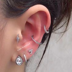 a woman wearing three different ear piercings