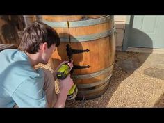 a man using a drill to fix a wooden barrel