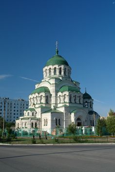 a large white and green building on the side of a road