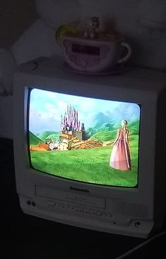 an old tv sitting on top of a bed with a castle in the back ground