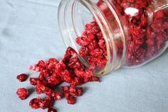 a jar filled with red candies sitting on top of a blue cloth covered table