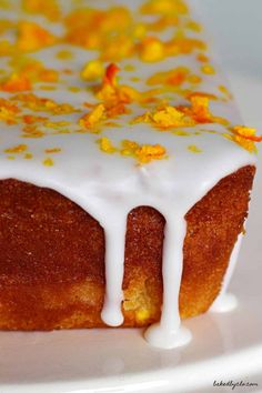 a cake with white icing and yellow sprinkles is on a plate