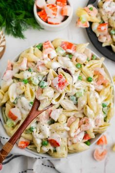 pasta salad with shrimp and peas in a white bowl