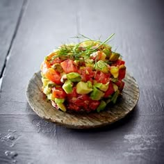 a salad on a wooden plate sitting on top of a table