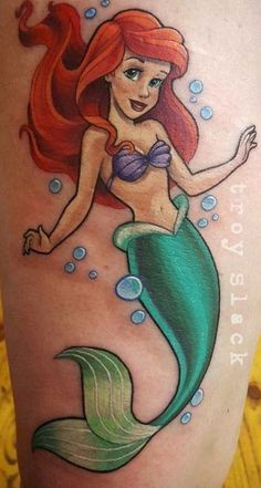 a mermaid tattoo on the back of a woman's leg