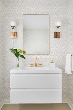 a white sink sitting under a mirror next to a wall mounted faucet in a bathroom