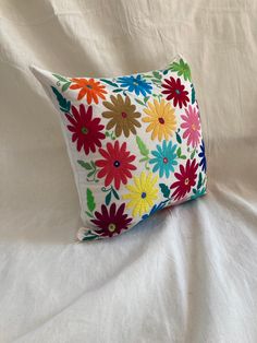 a white pillow with colorful flowers on it