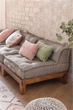 a living room with a couch, rug and potted plant on the side wall