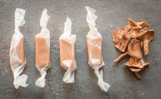 four different types of food wrapped in plastic wrappers next to an open mushroom on the ground