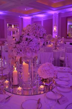 the centerpieces are filled with white flowers and lit candles