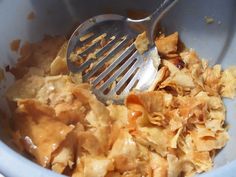 a blue bowl filled with food and a fork