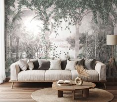 a living room with a couch, coffee table and wallpaper that has trees on it