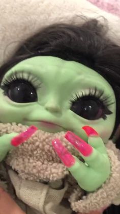 a close up of a doll with fake hair and green makeup on it's face