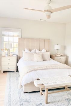 a bedroom with a large bed and white furniture