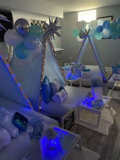 a living room filled with lots of white furniture and balloons