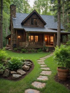 a log cabin with stone steps leading to the front porch and covered in grass, surrounded by trees