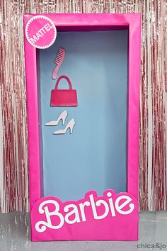 a barbie doll in a pink box with shoes and purse on the door that says barbie