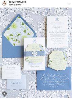 the wedding stationery is laid out on top of an ornate doily tablecloth