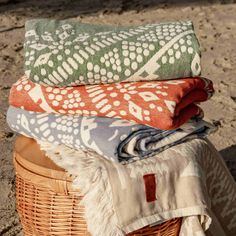 towels and blankets sitting on top of a wicker basket