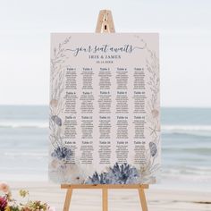 a wedding seating chart on an easel with flowers