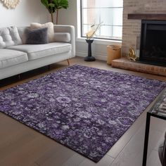 a living room filled with furniture and a purple rug on top of a hard wood floor