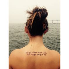 the back of a woman's neck with a quote written on her left shoulder