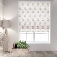 a white and gold patterned roman blind in a living room with wood flooring, potted plant and lamp