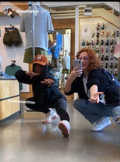 two people taking pictures in a clothing store