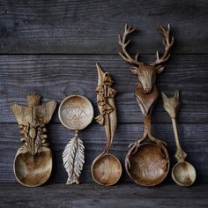 wooden spoons with carved deer heads and leaves are lined up against a wood background