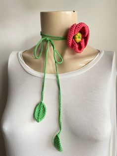 a crocheted flower is attached to a mannequin's neckline