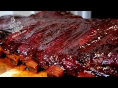 ribs covered in bbq sauce sitting on top of a cutting board