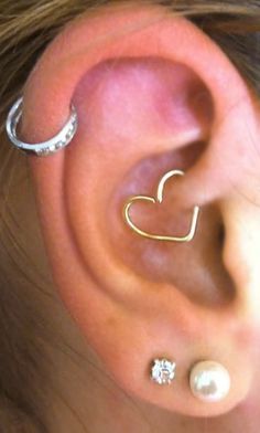 an ear with two different types of piercings on it