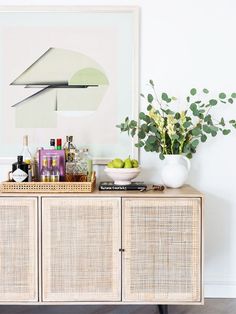 a table with some drinks on top of it next to a vase filled with flowers