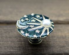 a close up of a decorative knob on a wooden surface