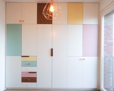 a room with white walls and multicolored cupboards