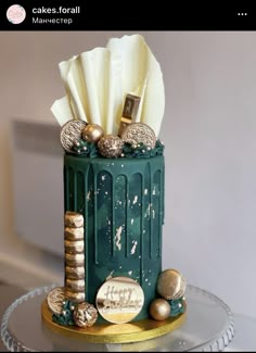 a green trash can with gold and silver decorations on it's top, sitting on a glass table