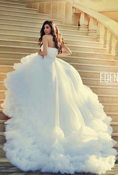 a woman in a white dress standing on some stairs