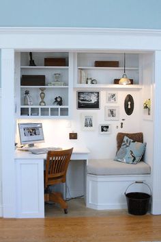 a home office with built in desk and shelves