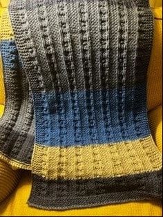 a crocheted blanket sitting on top of a yellow couch