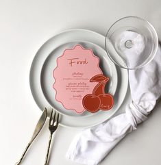 a white plate with a pink label on it next to silverware and napkins