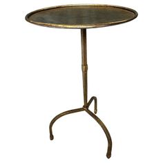 a table that has a metal base with a round top and legs on the bottom