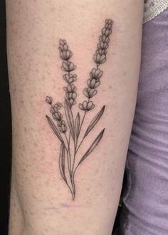 a woman's leg with a tattoo on it that has flowers growing out of it