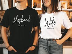 two people standing next to each other with their hands on their hipss and wearing t - shirts that say husband and wife