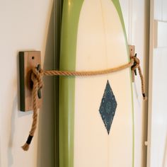 a green and white surfboard with a rope attached to it's back end