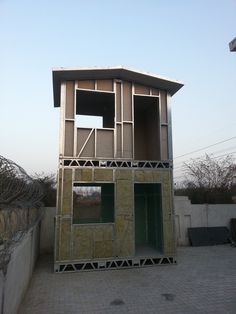 a small building that is being built with scaffolding on the sides and windows